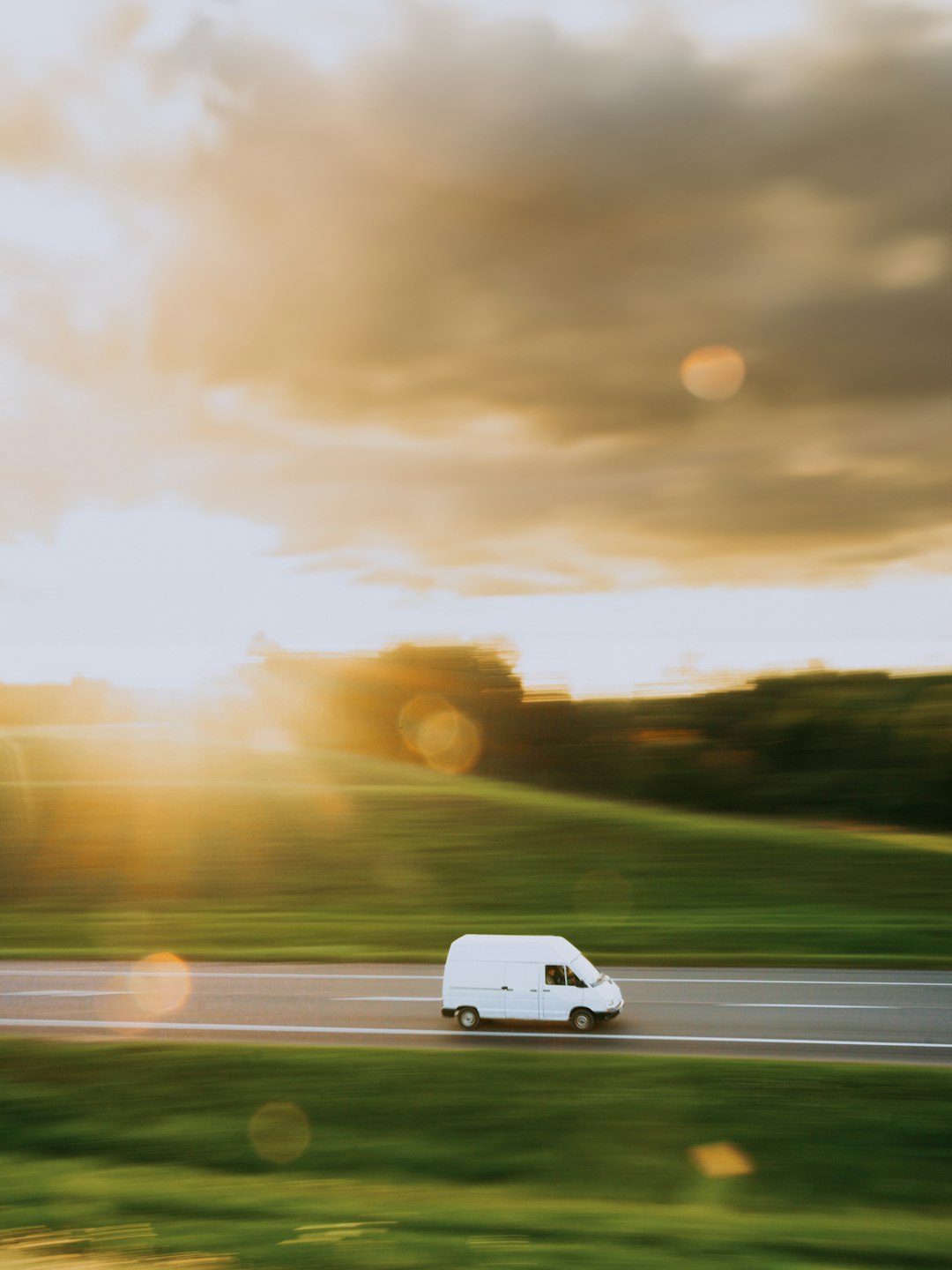 a white van driving down the highway at sunset